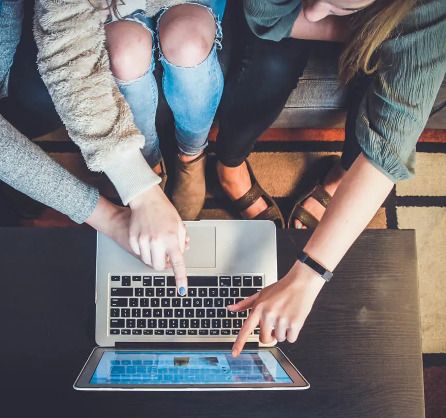 group of people gathered round a laptop